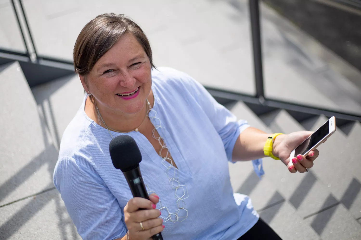 Heike mit Smartphone und Mikrofon